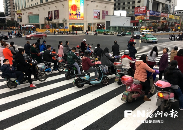 電動(dòng)車騎手停在斑馬線中間等綠燈　存在安全隱患