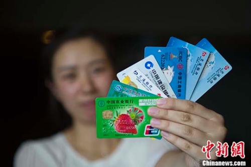 資料圖：山西太原，民眾展示銀行卡。 <a target='_blank' href='http://www.chinanews.com/' _fcksavedurl='http://www.chinanews.com/'>中新社</a>記者 張?jiān)?攝