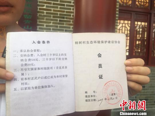 華一村協(xié)會會員展示會員證 劉崇婉 攝