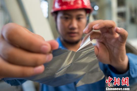 僅有A4紙四分之一厚度的“手撕鋼”，在工作人員的手中被輕而易舉地撕碎。　韋亮 攝